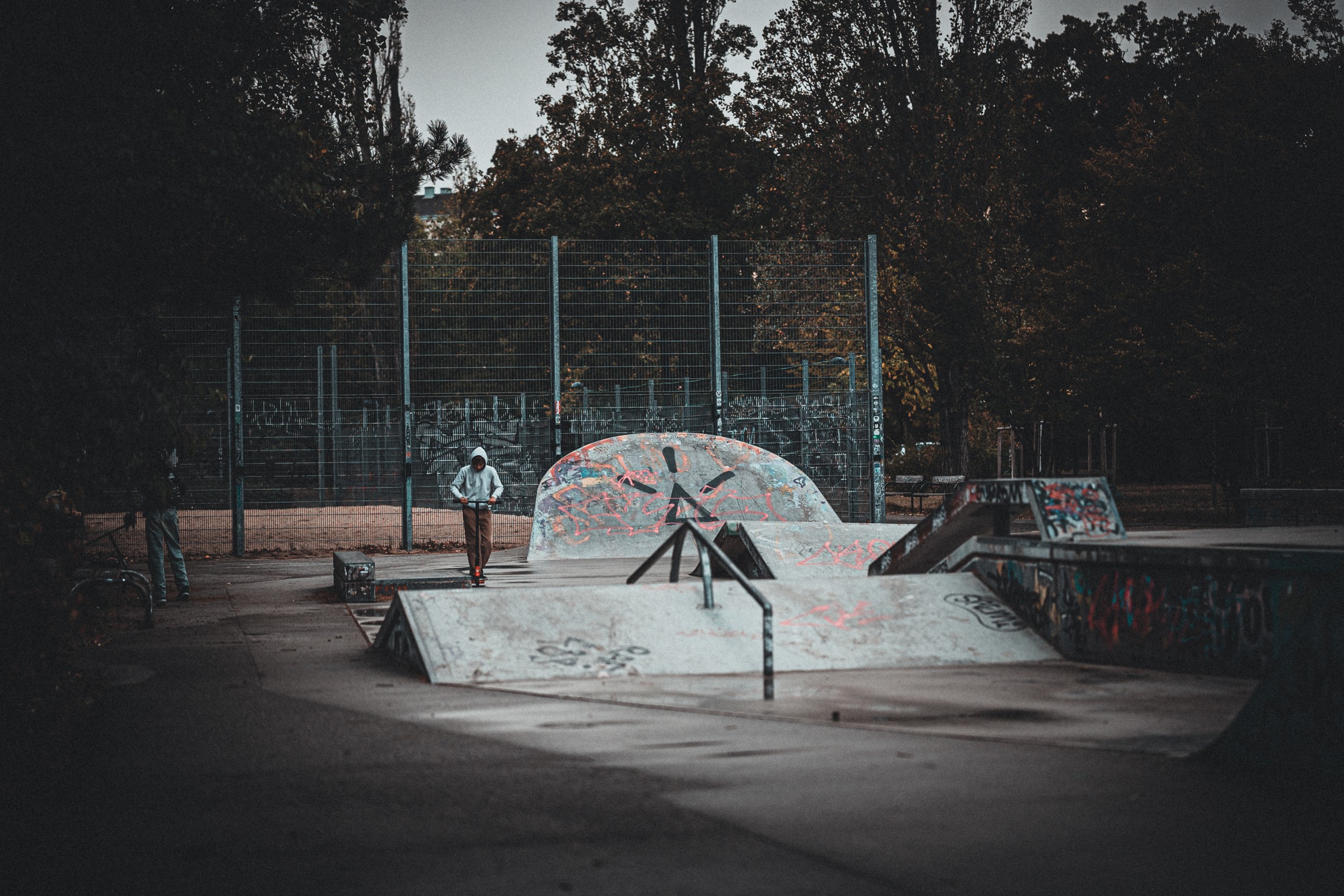 Ein Rollerfahrer zwischen Rampen und Graffiti in einem Wiener Skatepark