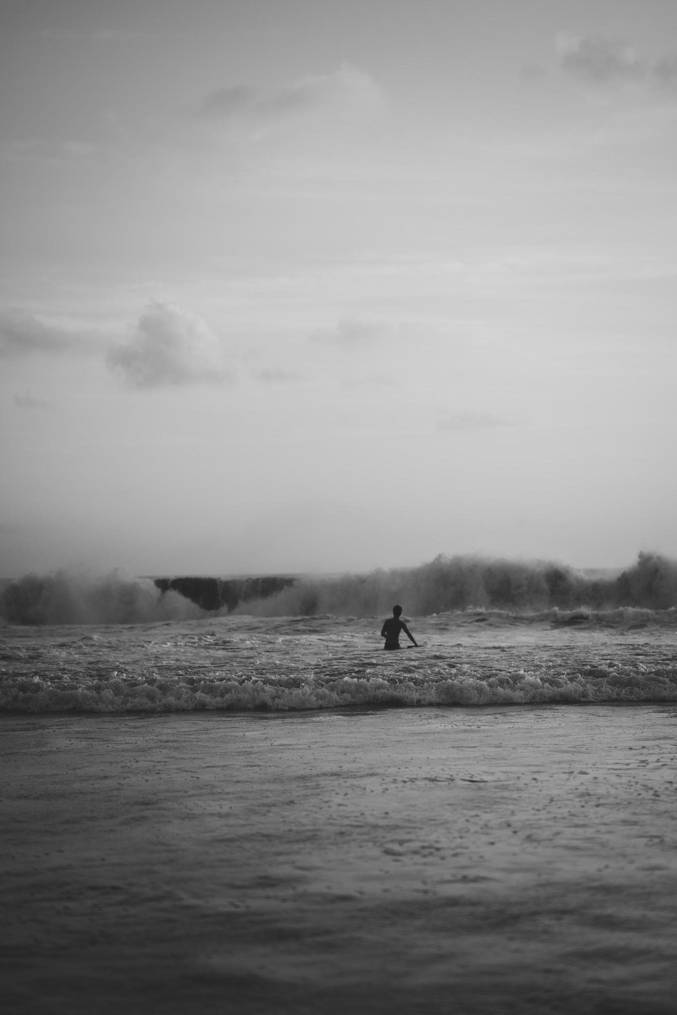 A lone figure by the sea in black and white