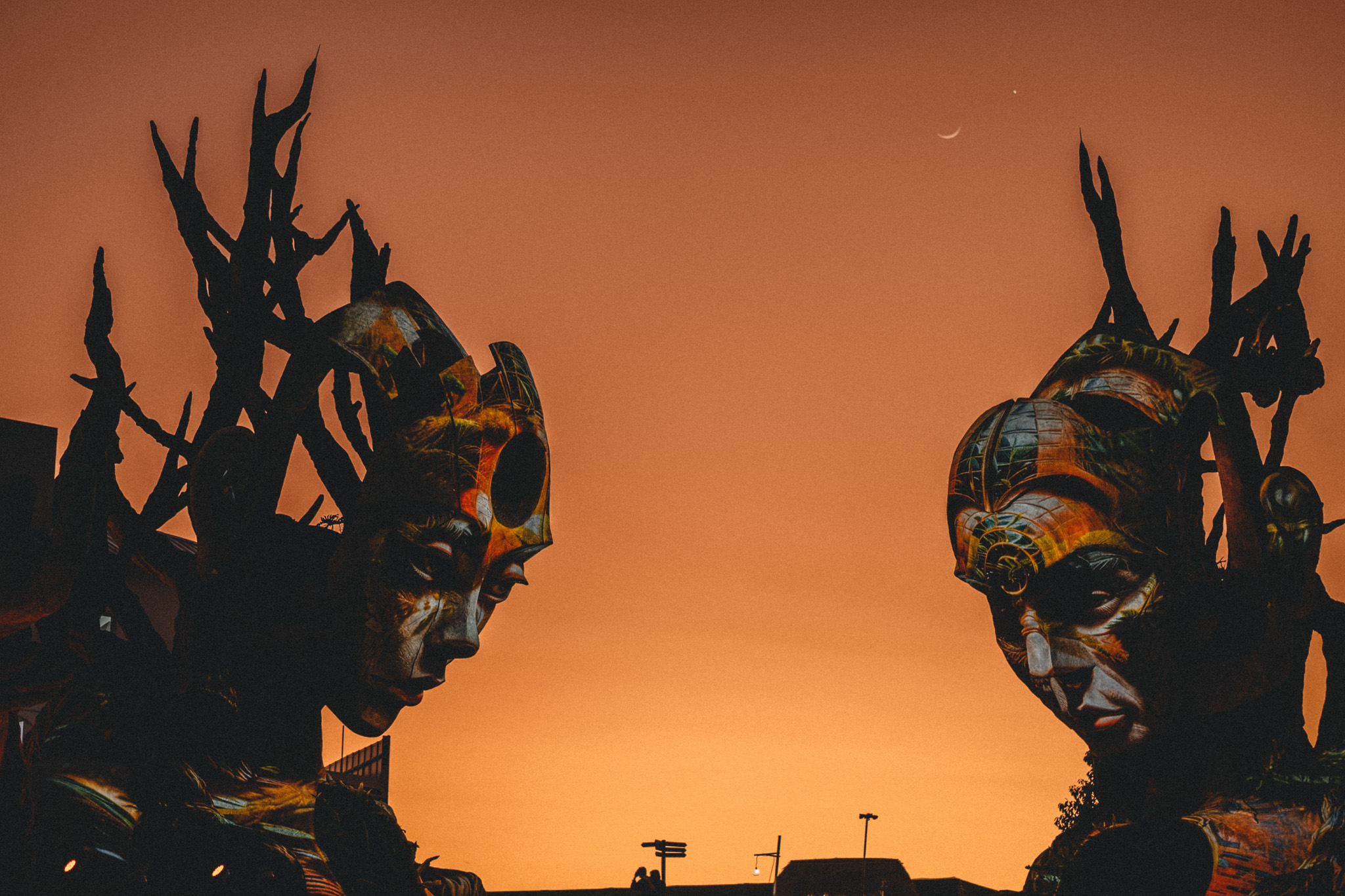 Two ornate sculptures silhouetted against an orange sky