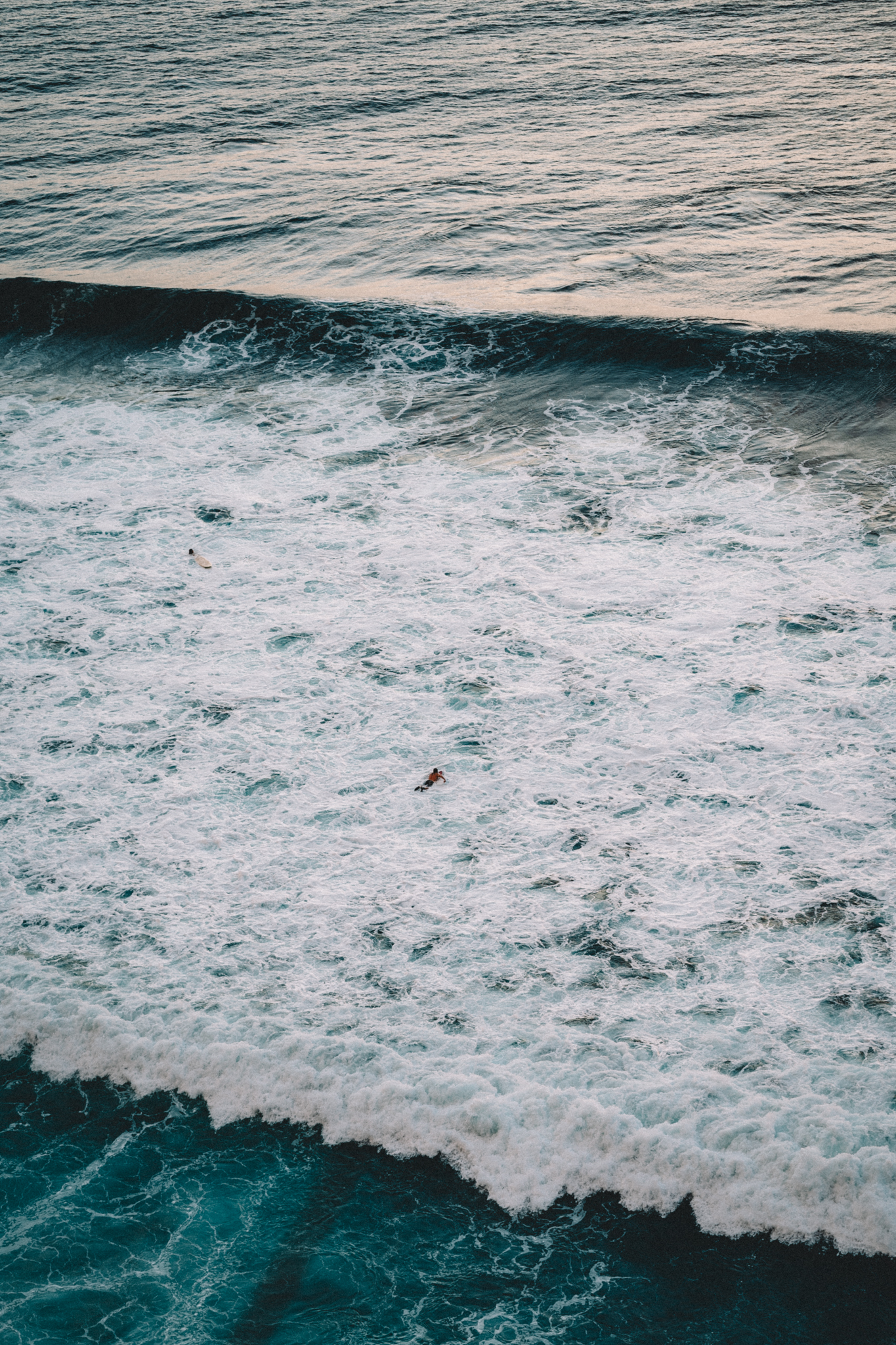 A wave breaking into textured white water from above