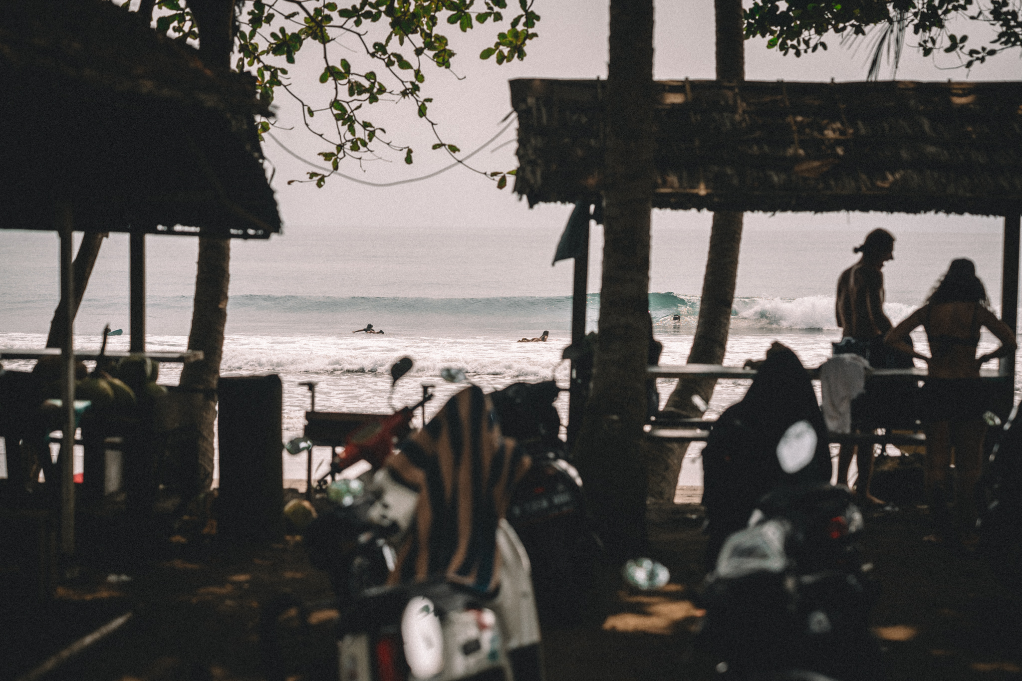 A beachside shelter with people silhouetted against the sea