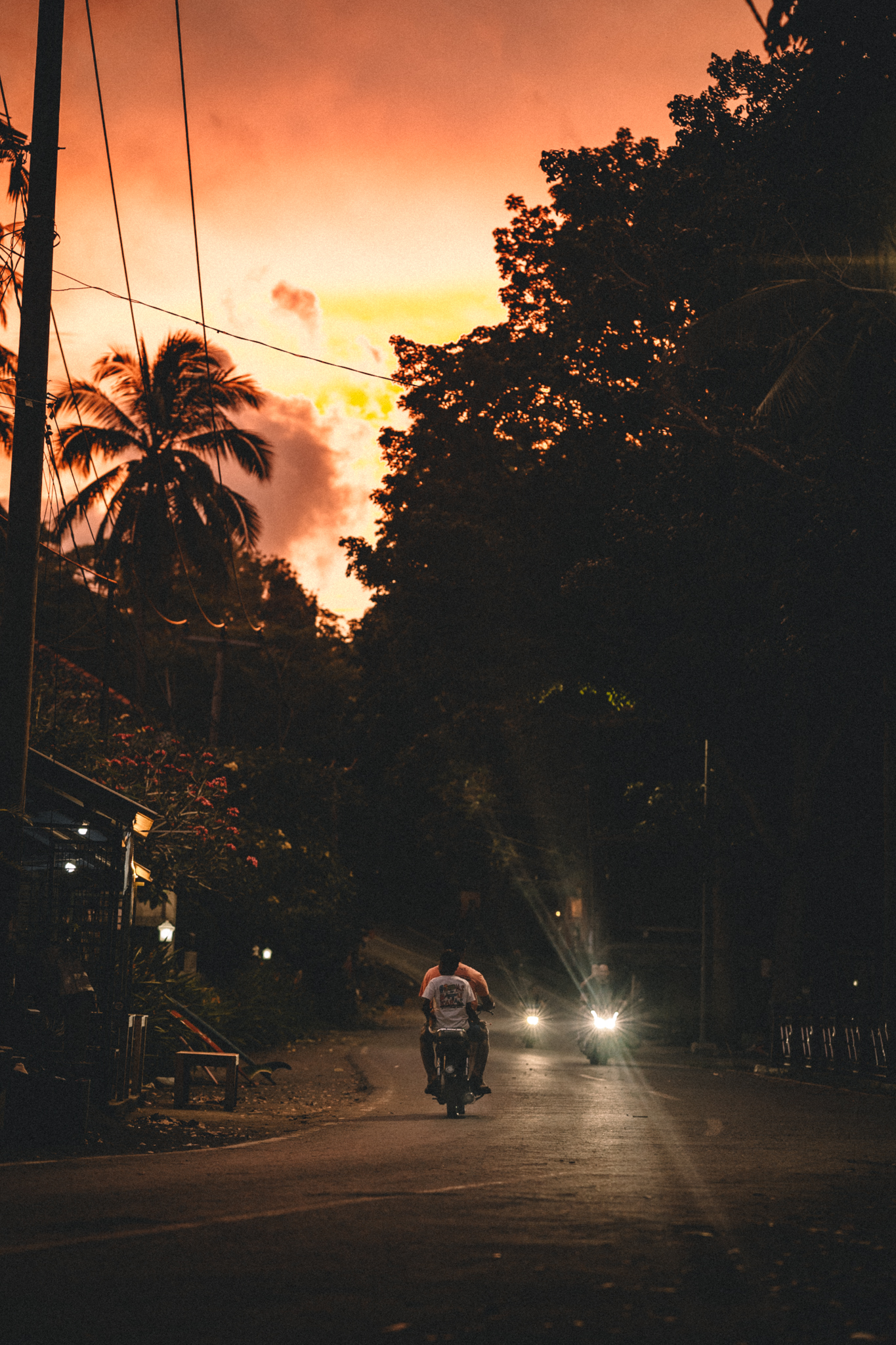 A motorbike passing beneath an orange evening sky