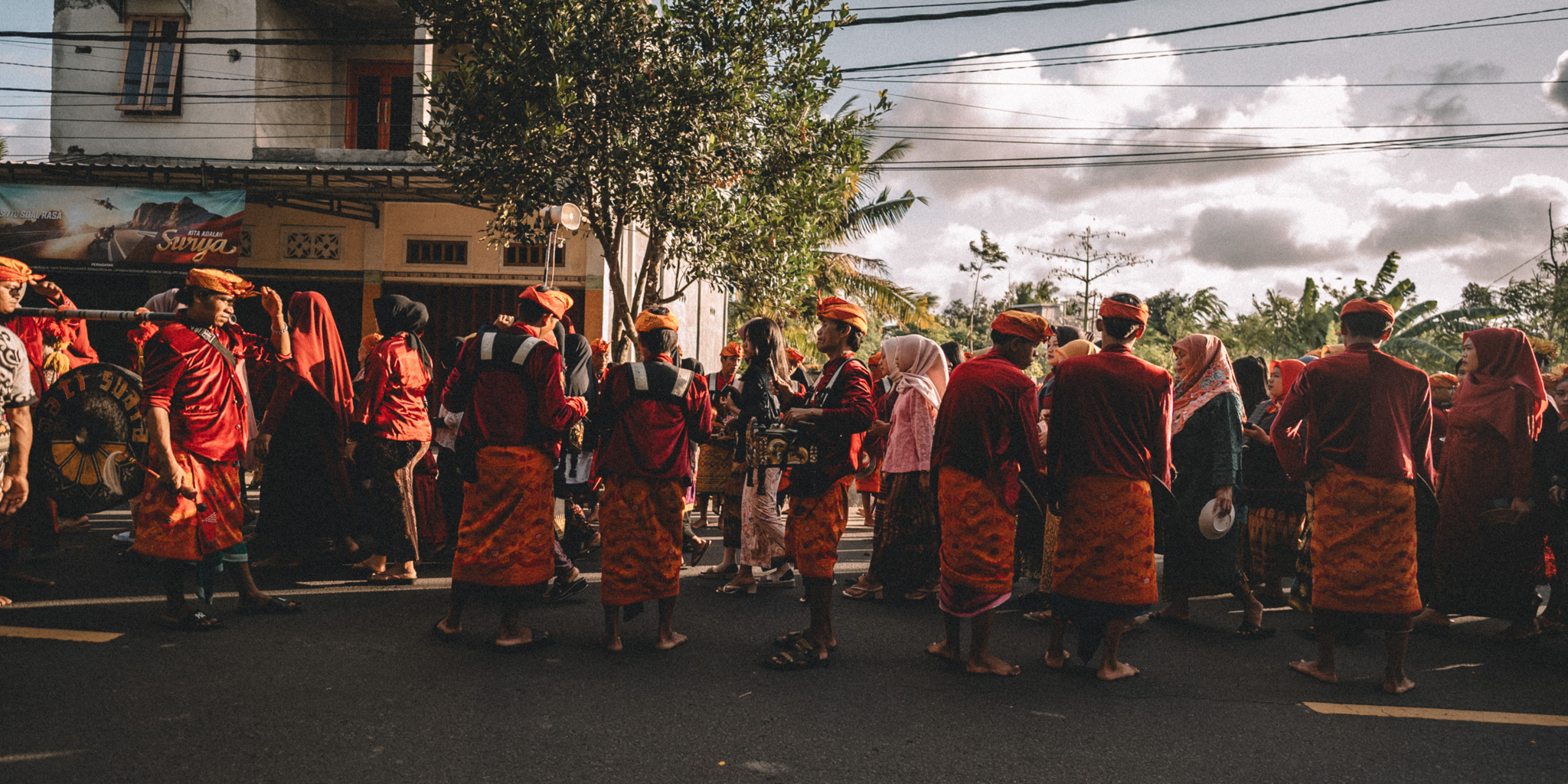 A street procession in red and orange clothing