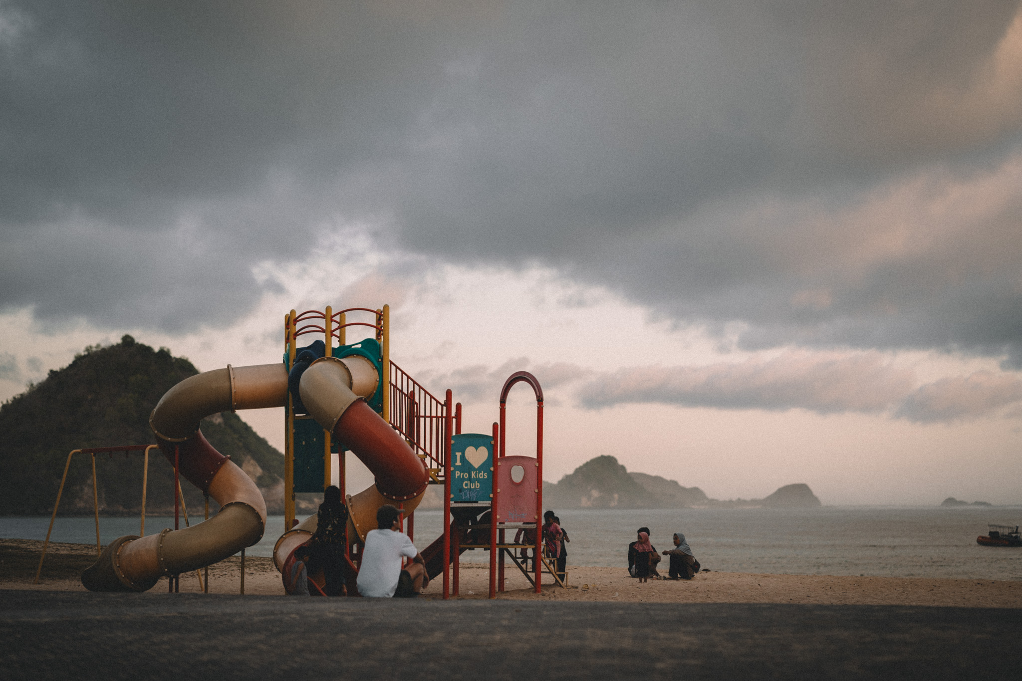 A seaside playground beneath dark clouds