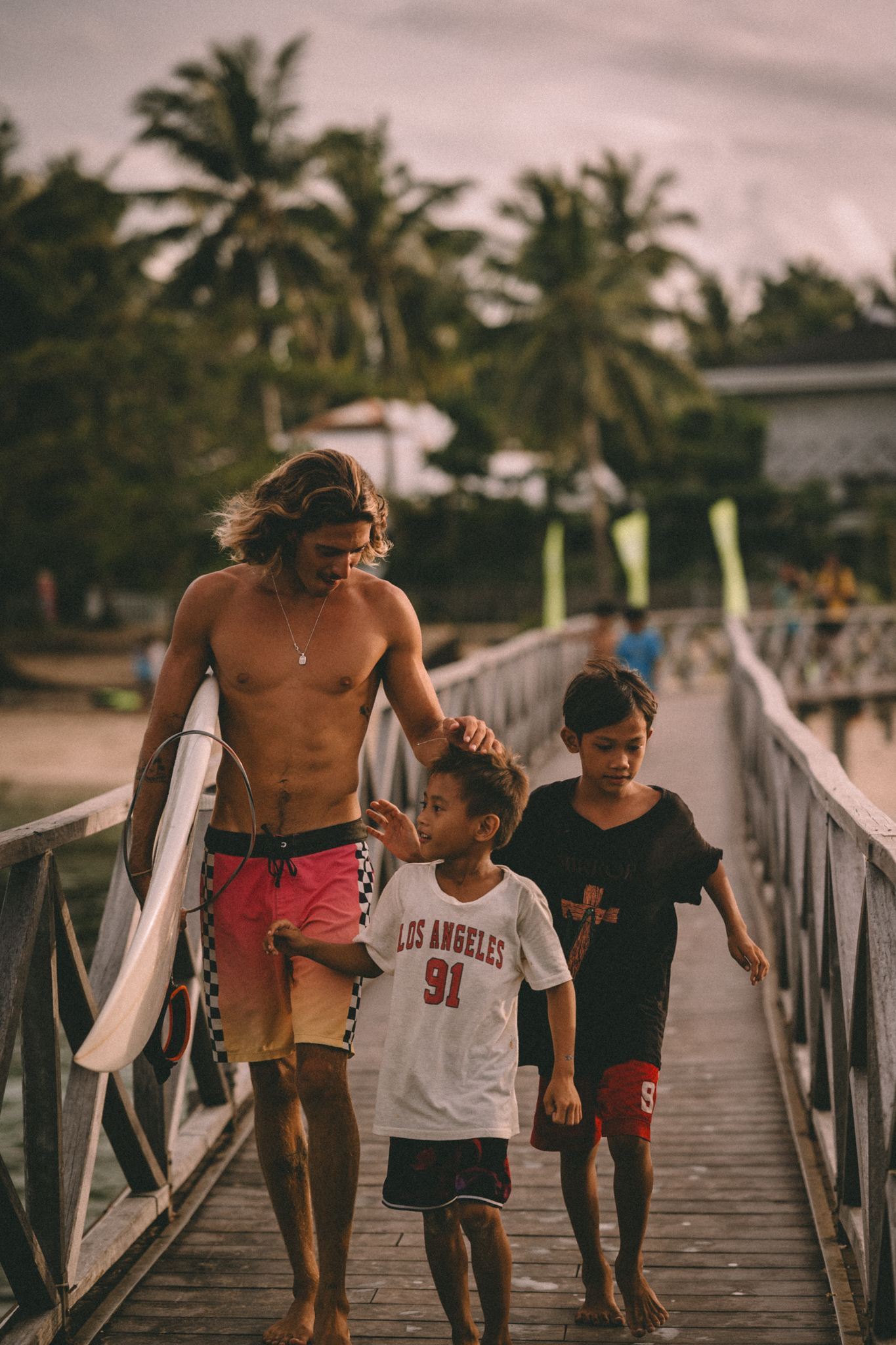 A man and two children walking along a bridge